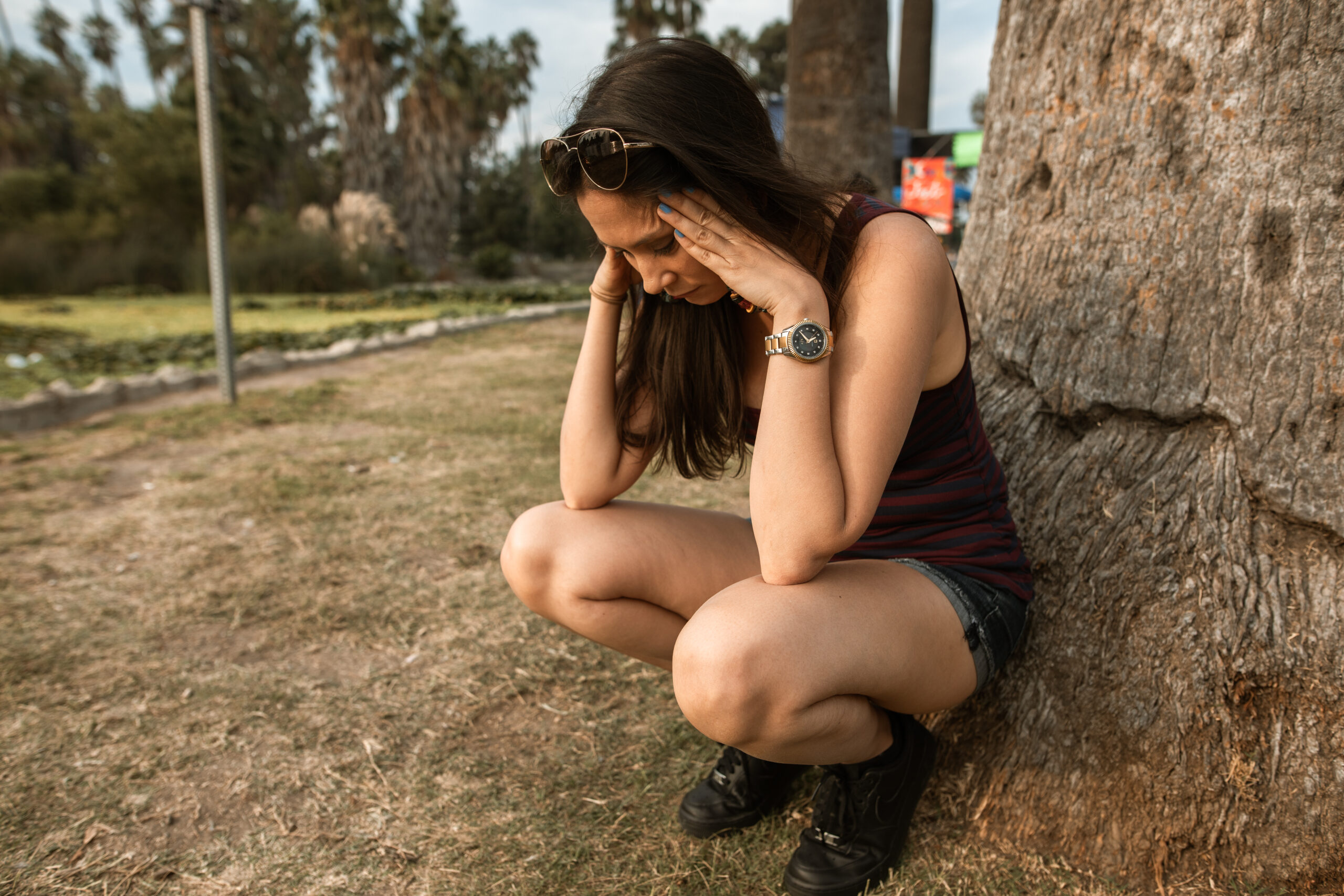 a person looking stressed next to a tree