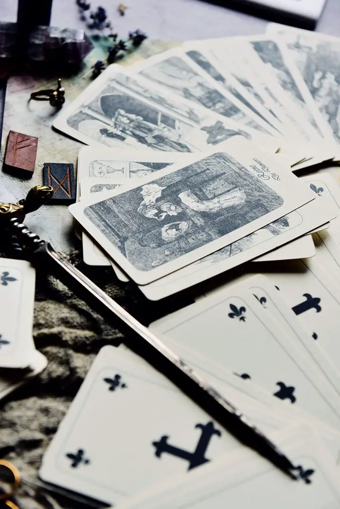 A steel magic wand beside a set of tarot cards